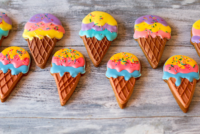 Glazed sweets on wooden background. Ice cream cone cookies. Delicious sugar biscuits. Best dessert for children.